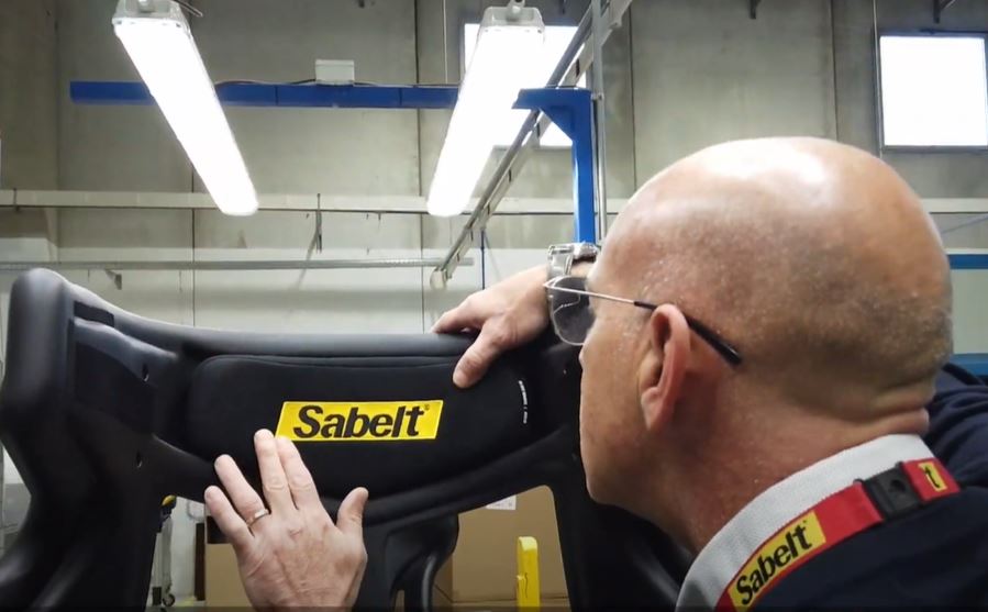 Men inspecting a racing car seat with his hands