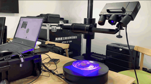 Scanning setup with 3D scanner and laptop, scanning a small object